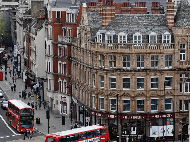 aerial photography of buses on road between European styled building